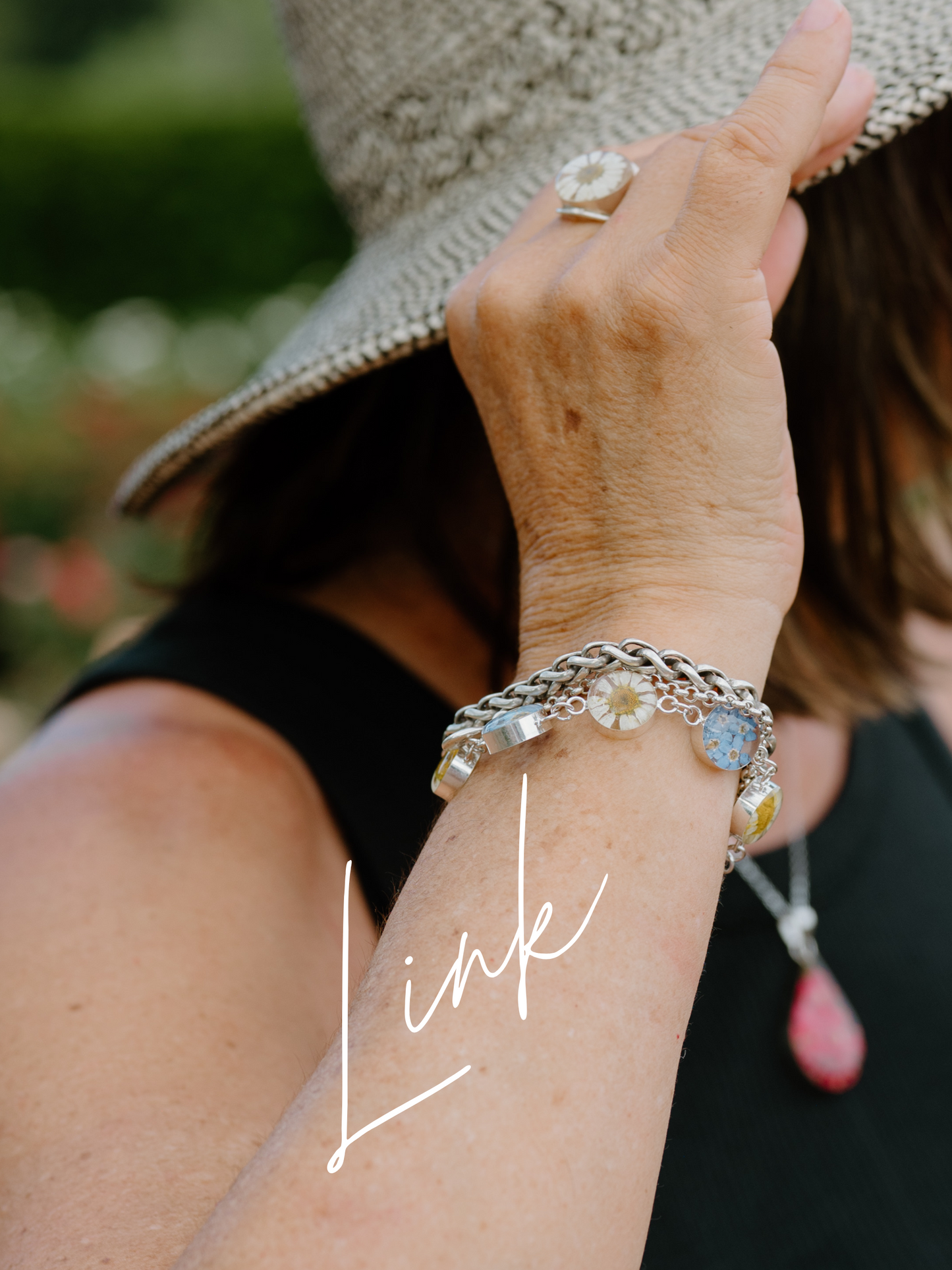 Close-up of a person's arm wearing multiple bracelets with a blurred background