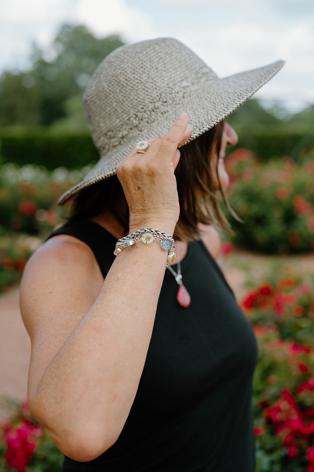 Person wearing a wide-brimmed hat with a blurred floral background