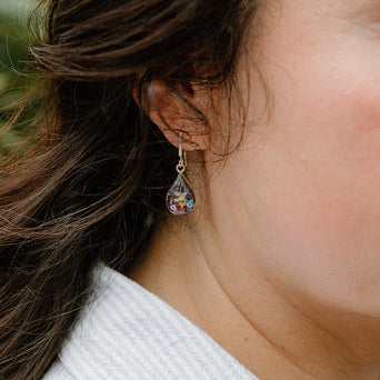 Close-up of a woman wearing a colorful earring outdoors